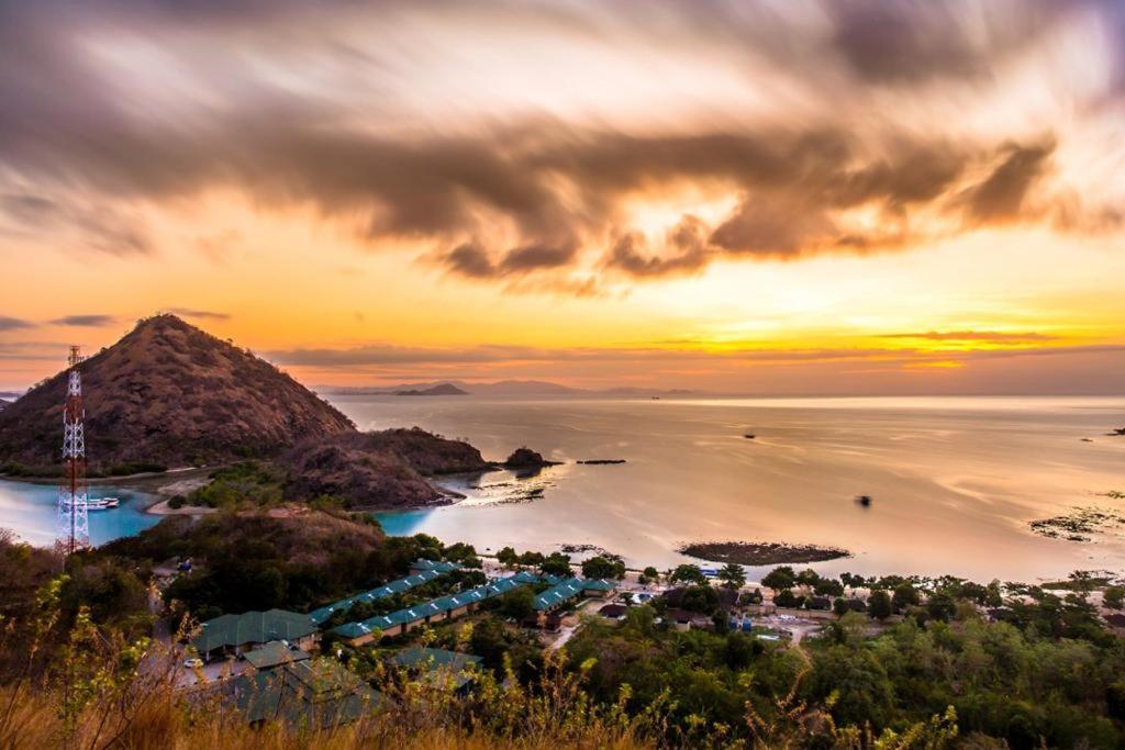 an aerial view of a resort in the ocean at sunset at Sylvia Hotel & Resort Komodo in Labuan Bajo