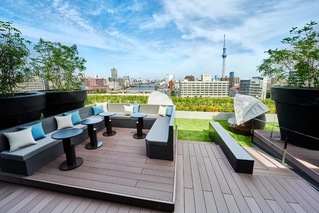 a rooftop patio with couches and tables on a building at The Gate Hotel Ryogoku by Hulic in Tokyo