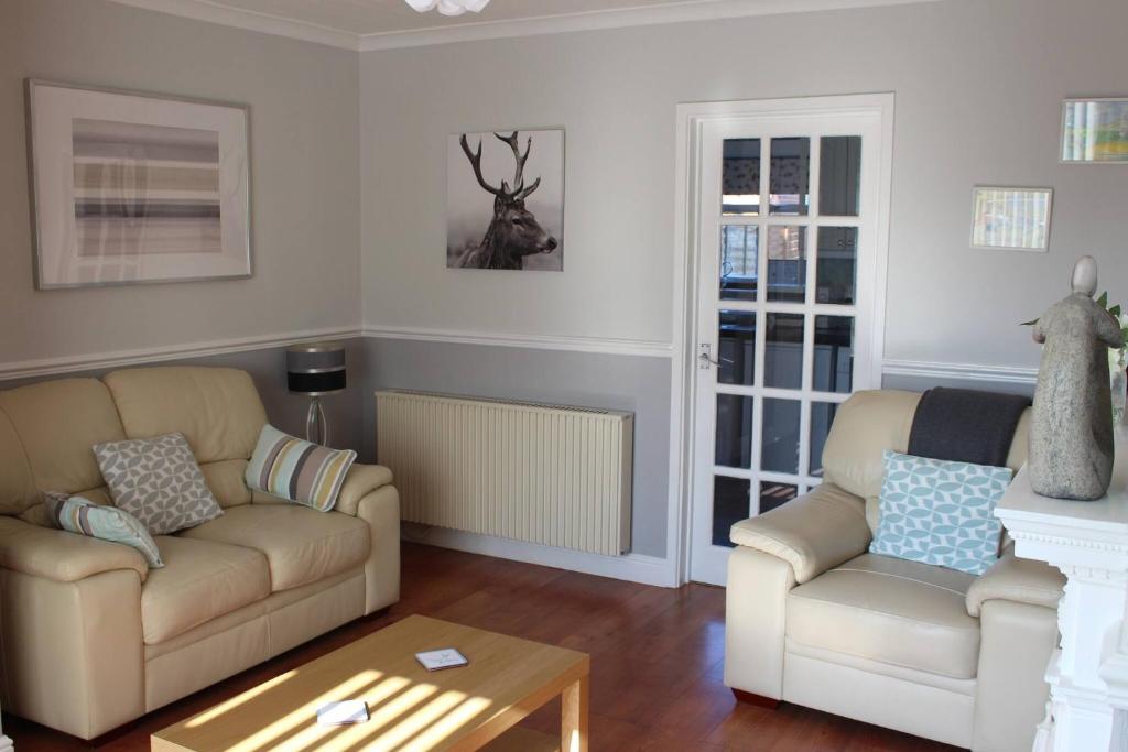 a living room with two couches and a table at Potters House Coventry warwickshire in Coventry