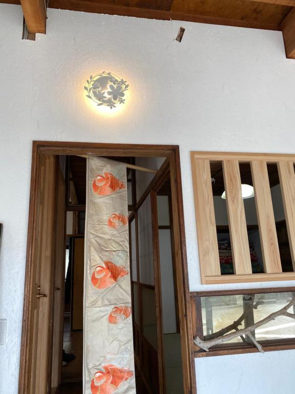 a room with two windows and a chandelier on the wall at 沼津ライダーハウスしんちゃん in Numazu