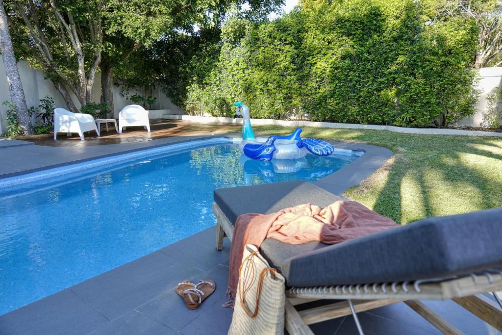 a swimming pool with a chaise lounge next to a swimming pool at The Shack Noosa in Noosa Heads