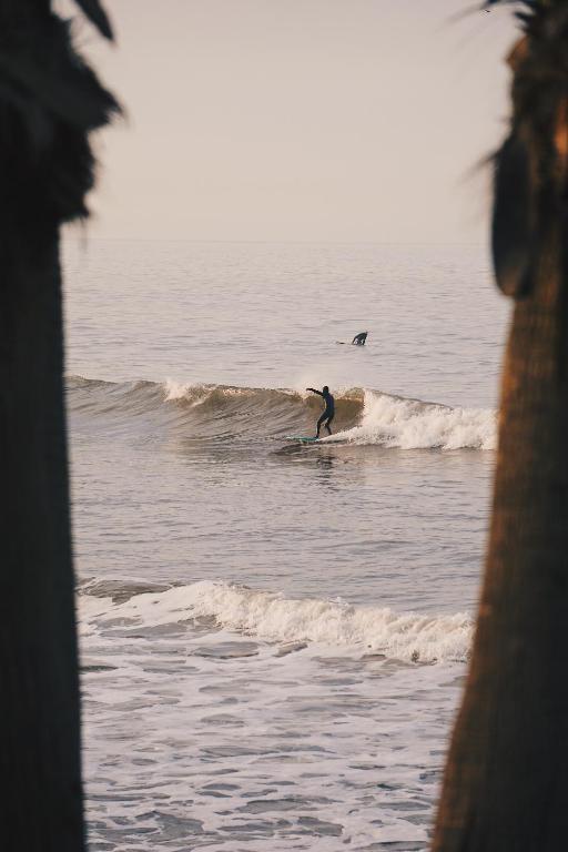 a man riding a wave on a surfboard in the ocean at The Mantra Hotel Kata Noi in Kata Beach