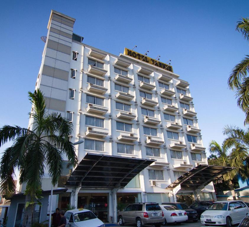 un hotel con coches aparcados delante en Hotel Yankin, en Yangón