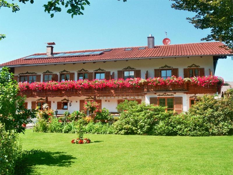 a large house with flowers in the yard at Gästehaus Hubertushof in Bad Feilnbach