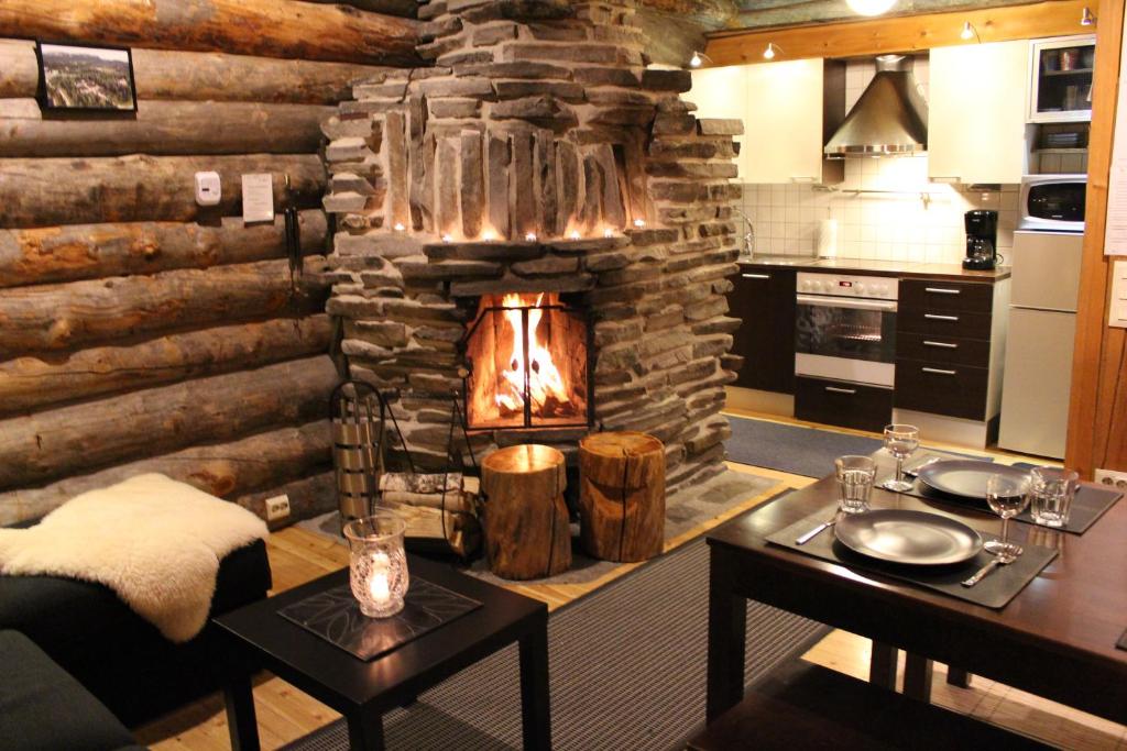 a living room with a stone fireplace in a kitchen at Rantaruka Apartment II in Ruka