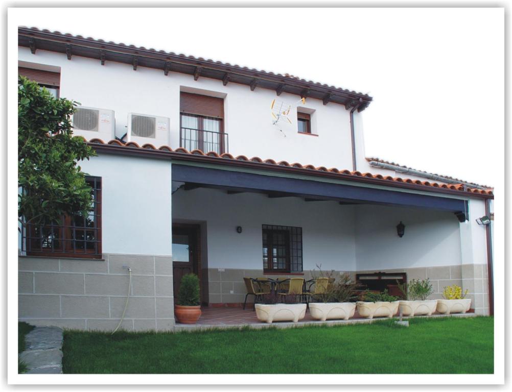 a white house with a patio in front of it at Casa Rural Tia Tomasa in Malpartida de Plasencia