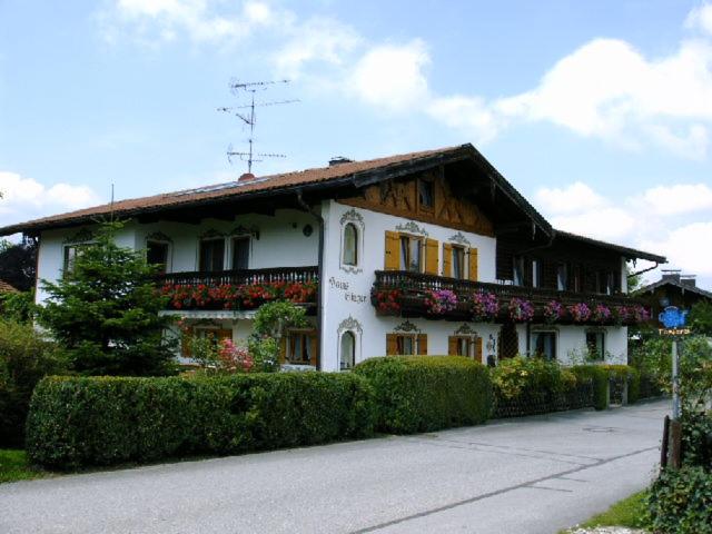 a white house with flowers in front of it at Haus Singer in Bad Feilnbach