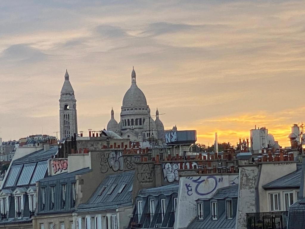 a view of a city with buildings and a clock tower at m-Otel in Paris
