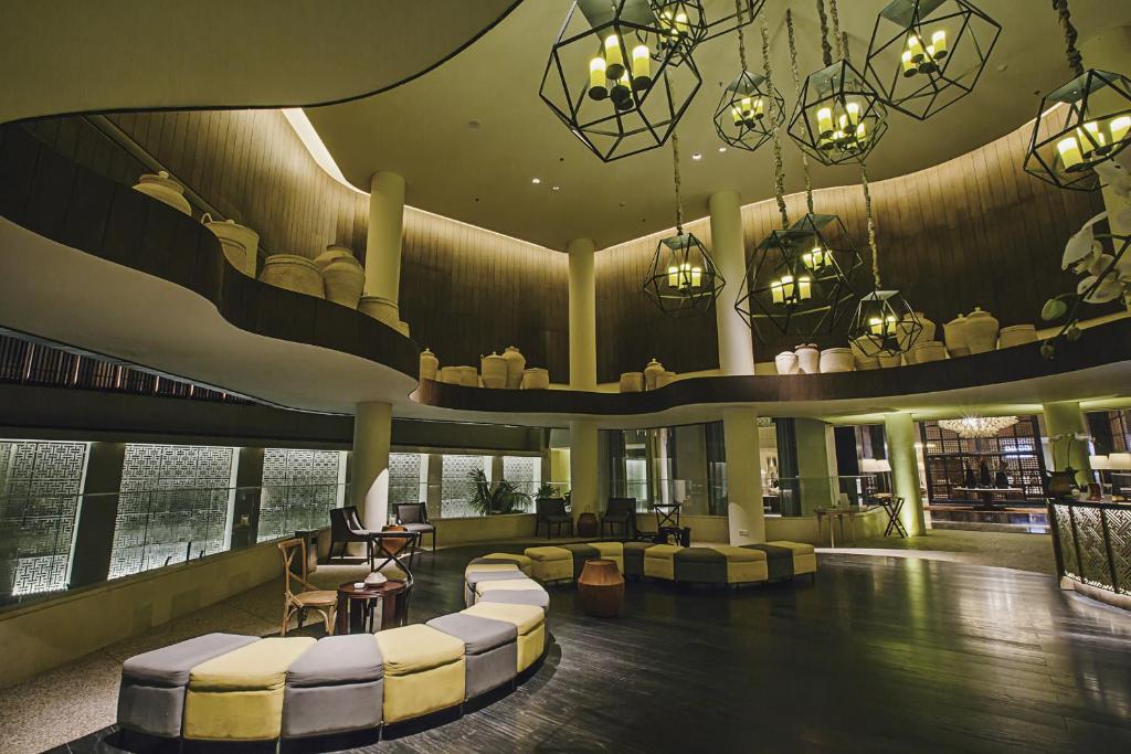 a lobby with couches and chairs in a building at Bali Paragon Resort Hotel in Jimbaran