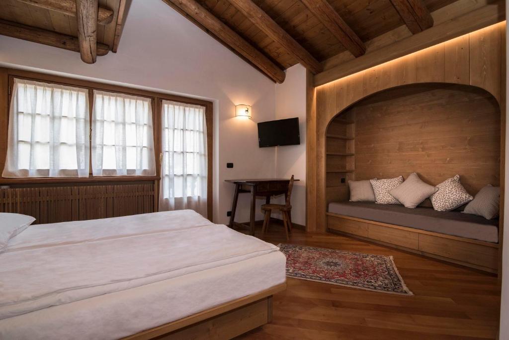 a bedroom with a large bed and a desk at Ca'Milla B&B nelle Dolomiti in Pieve di Cadore