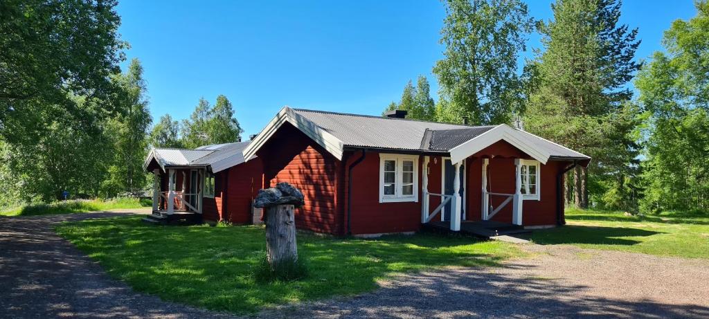 a small red house in the middle of a field at Hamra Stugby - Nature Adventures Hamra in Hamra