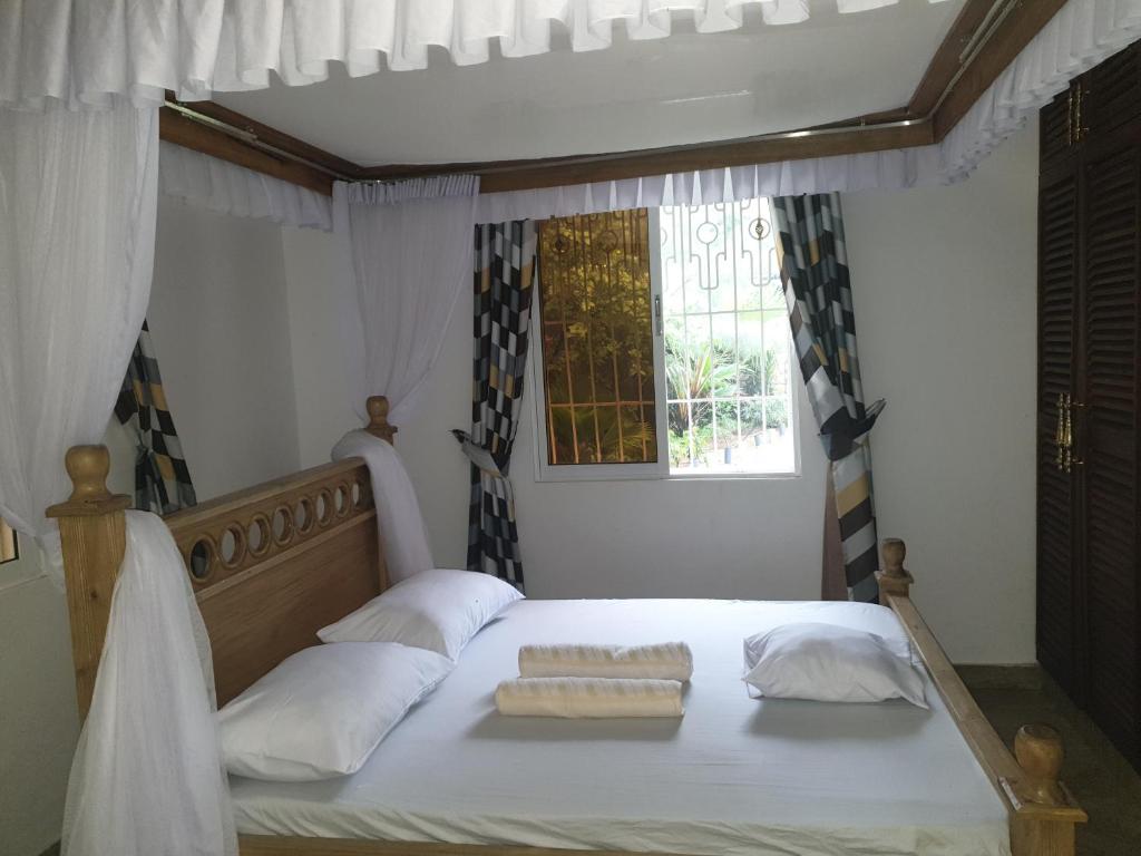 Postel nebo postele na pokoji v ubytování Karibuni palace mtwapa