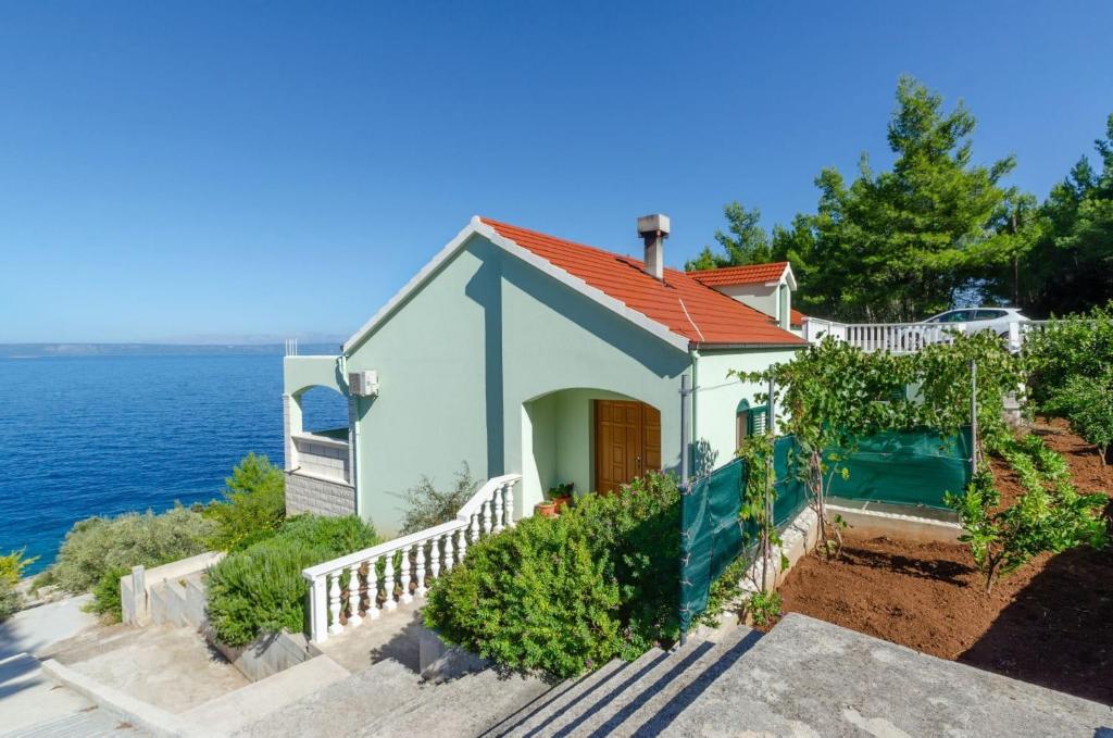 una piccola casa con tetto rosso vicino all'oceano di Seafront Holiday Home Marija a Prigradica