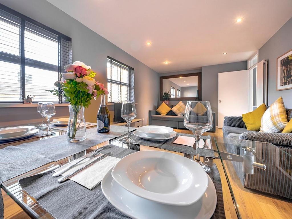 ein Wohnzimmer mit einem Tisch mit Glasplatte in der Unterkunft Pass the Keys - 2BR Luxury Apartment with Jacuzzi Bath in Belfast