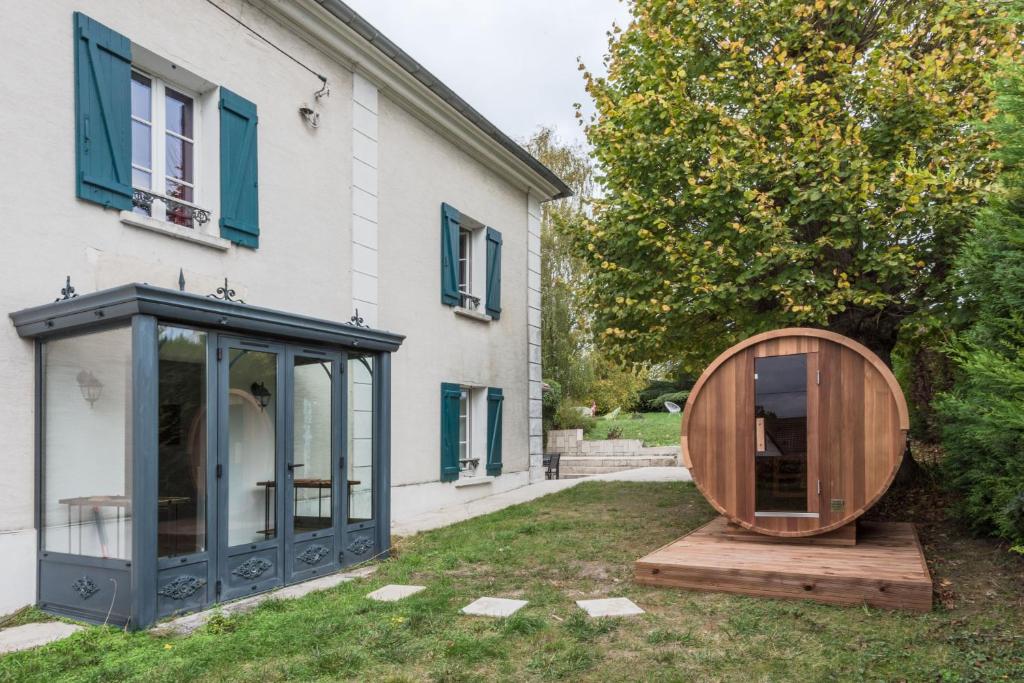 una sfera di legno si trova accanto a una casa di Standing cottage in Disneyland a Chalifert