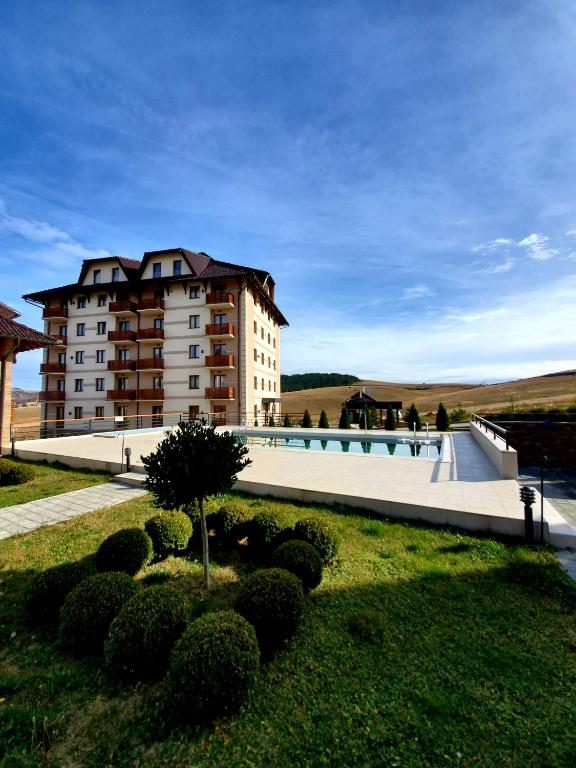 a large building with a swimming pool in front of it at Zlatibor Hills Royal in Zlatibor