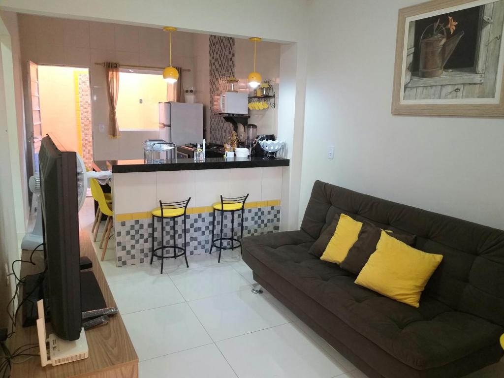 sala de estar con sofá y cocina en Flor de Peroba Flats #1 Amarelo - Maragogi - AL, en Maragogi
