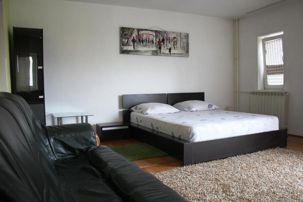 a bedroom with a bed and a couch at Decebal 1 Premium apartment in Bucharest