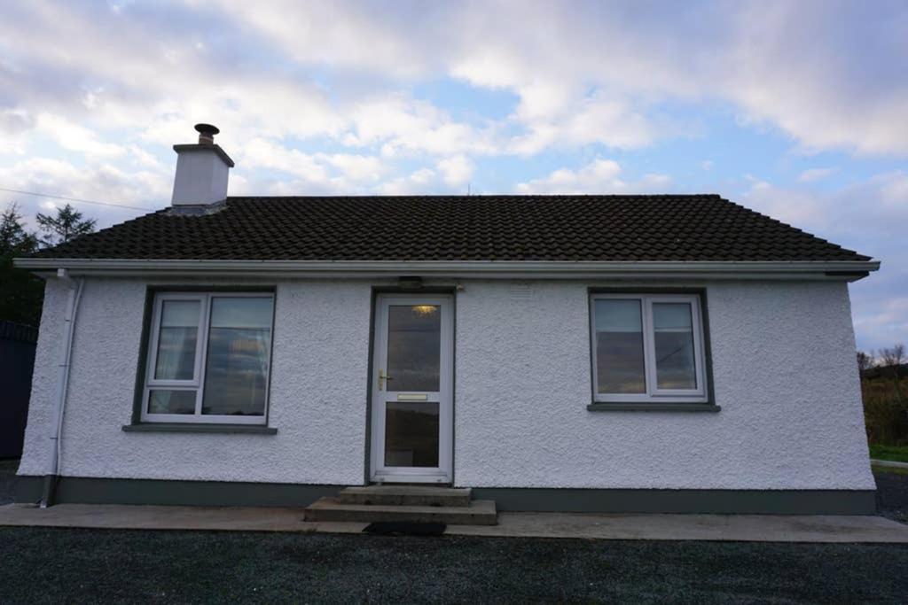 a white house with a chimney on top of it at Lignaul Cottage in Donegal