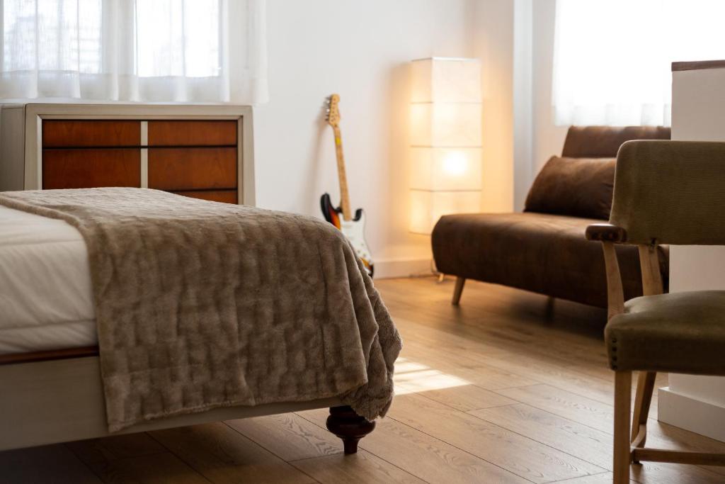 1 dormitorio con 1 cama, 1 sofá y 1 silla en Txoko en Pamplona