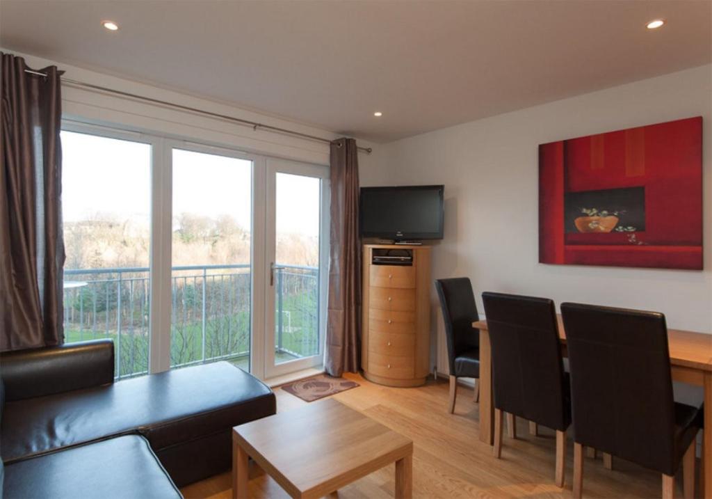 uma sala de estar com uma mesa e uma sala de jantar em The Lochend Park View Residence em Edimburgo