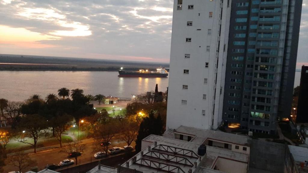 einen Blick auf einen Fluss von einem Gebäude mit einem Schiff im Wasser in der Unterkunft Parana in Rosario