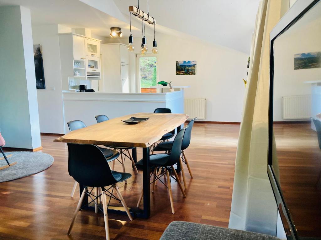 Un comedor con mesa y sillas de madera. en Alpensoul Apartments, en Zell am See