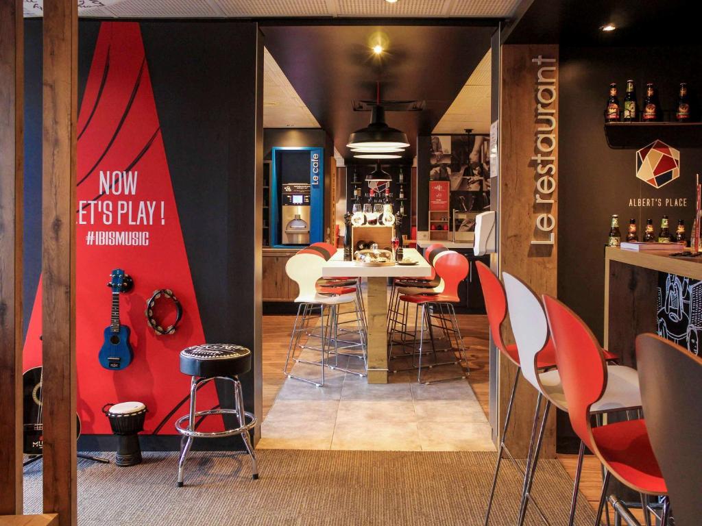 a restaurant with a table and chairs and a bar at ibis Paris Gennevilliers in Gennevilliers