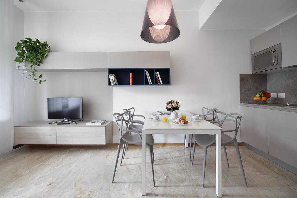 a kitchen and dining room with a white table and chairs at Contempora Apartments - Elvezia 8 - E22 in Milan