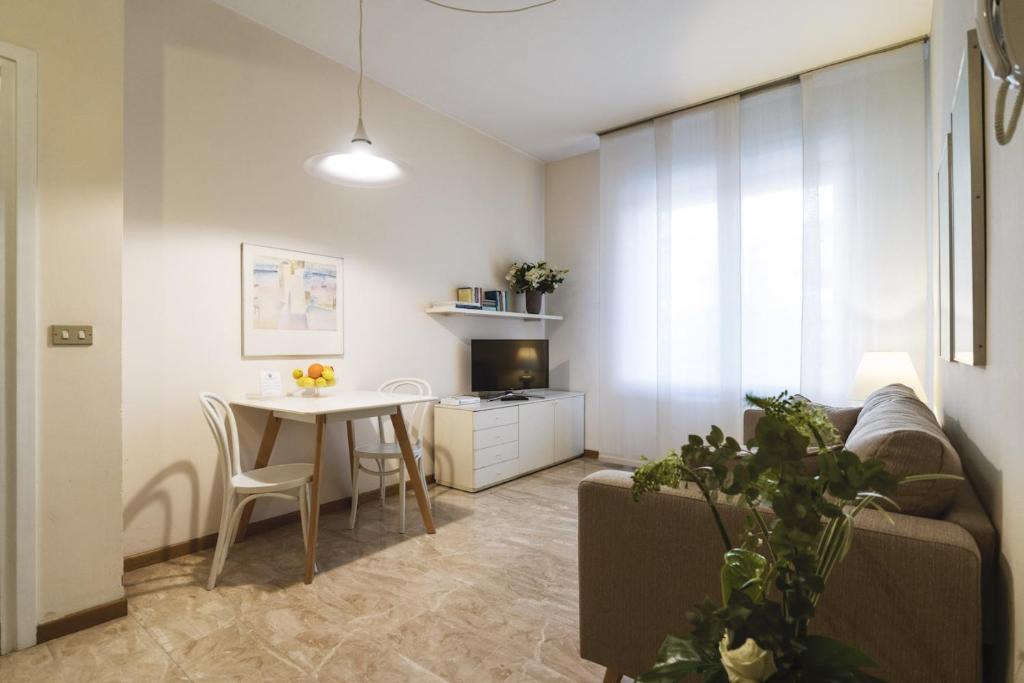 a living room with a couch and a table at Contempora Apartments - Elvezia 8 - E24 in Milan