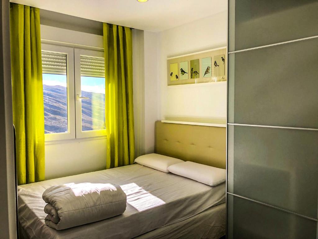 Łóżko lub łóżka w pokoju w obiekcie Apartamentos Sierra Nevada Prime Bluettravel