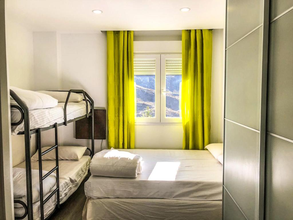 Pokój z 2 łóżkami piętrowymi i oknem w obiekcie Apartamentos Sierra Nevada Prime Bluettravel w mieście Sierra Nevada
