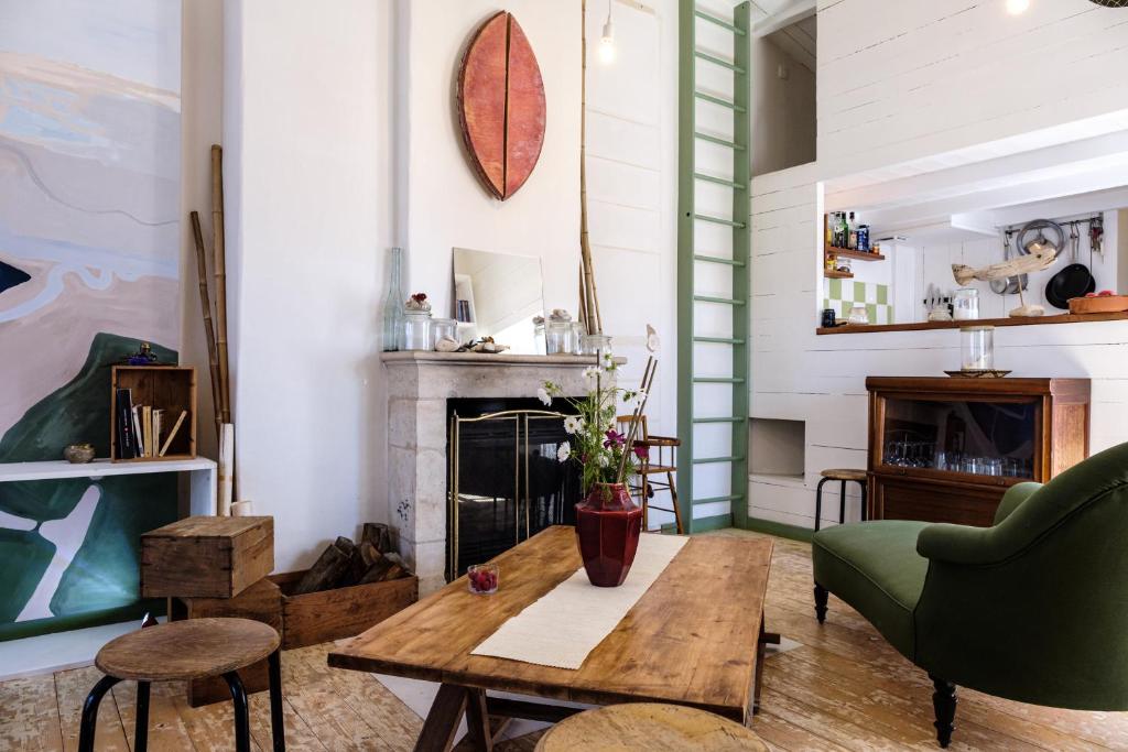 a living room with a table and a fireplace at Logement Design à Loix-en-Ré - 2 étoiles - Centre Village in Loix