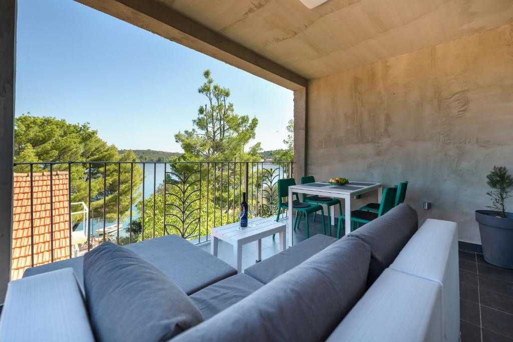 ein Wohnzimmer mit einem Sofa und einem Balkon in der Unterkunft Feel Dugi otok apartments in Luka