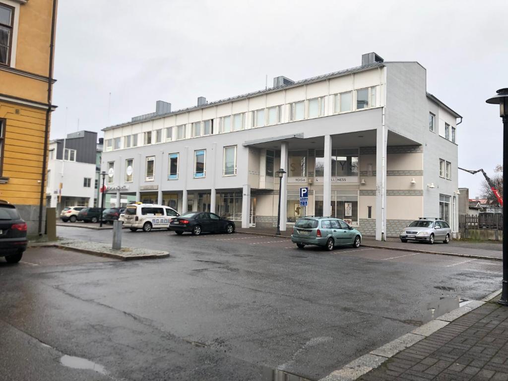 a parking lot with cars parked in front of a building at Hostel400Kokkola Extend in Kokkola