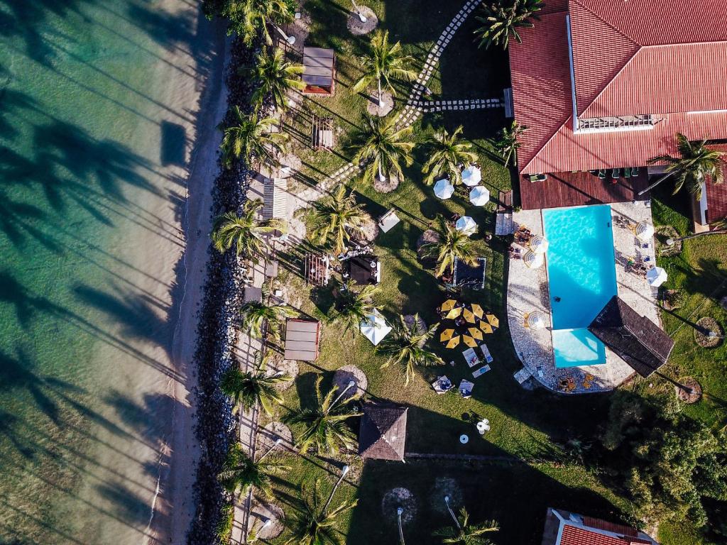 an overhead view of a resort with palm trees and a swimming pool at Pousada Caeira in Morro de São Paulo