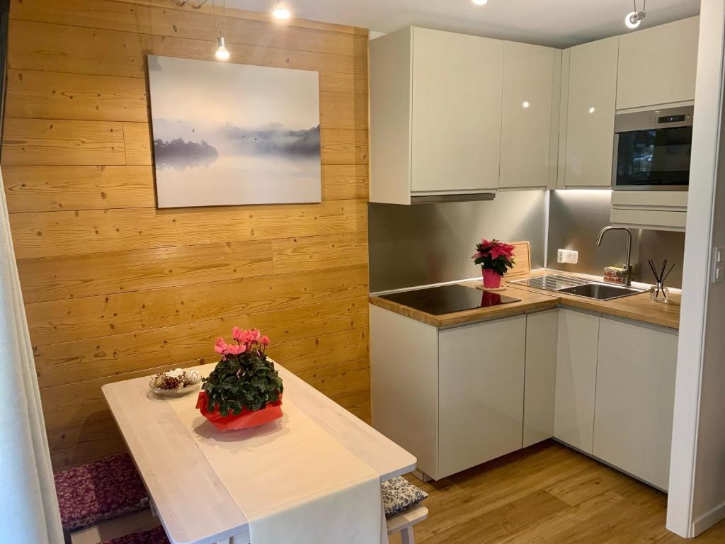 uma cozinha com armários brancos e uma mesa com flores em Les Pierres Blanches Mont Blanc em Les Contamines-Montjoie