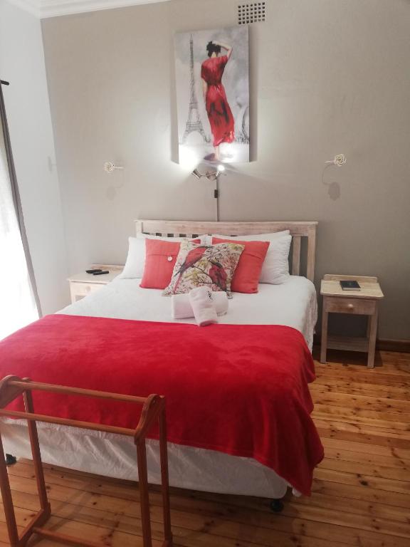 a bedroom with a large bed with a red blanket at LORD WILLIS in Williston