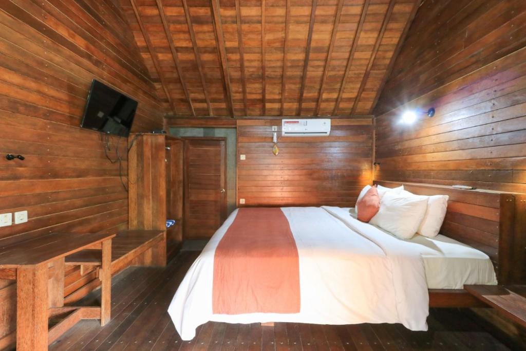 a bedroom with a bed in a wooden room at Waterside inn Nusa Penida in Nusa Penida