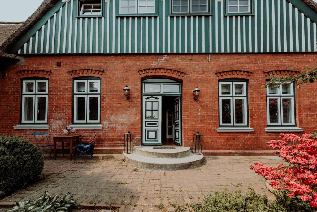 un edificio in mattoni rossi con una porta e un tavolo di Landhaus Kurzenmoor - FeWo Sommerhaus, 100 qm 