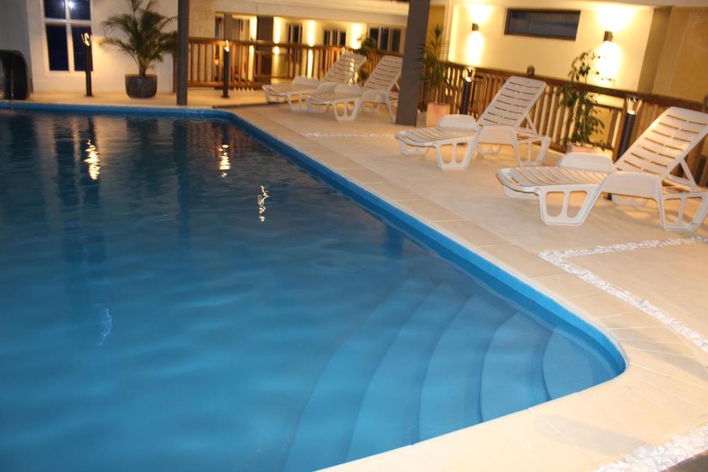 a swimming pool with lounge chairs and a hotel at Sikamifer Tourist Resort in Quatre Bornes
