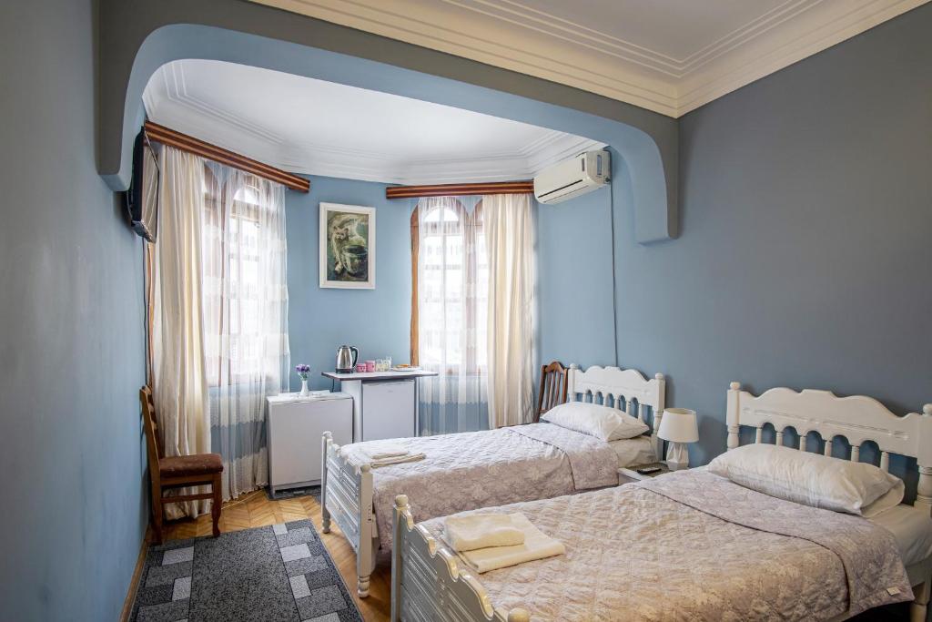 ein blaues Schlafzimmer mit 2 Betten und einem Tisch in der Unterkunft Sweet Home at Ninoshvili 3 in Batumi