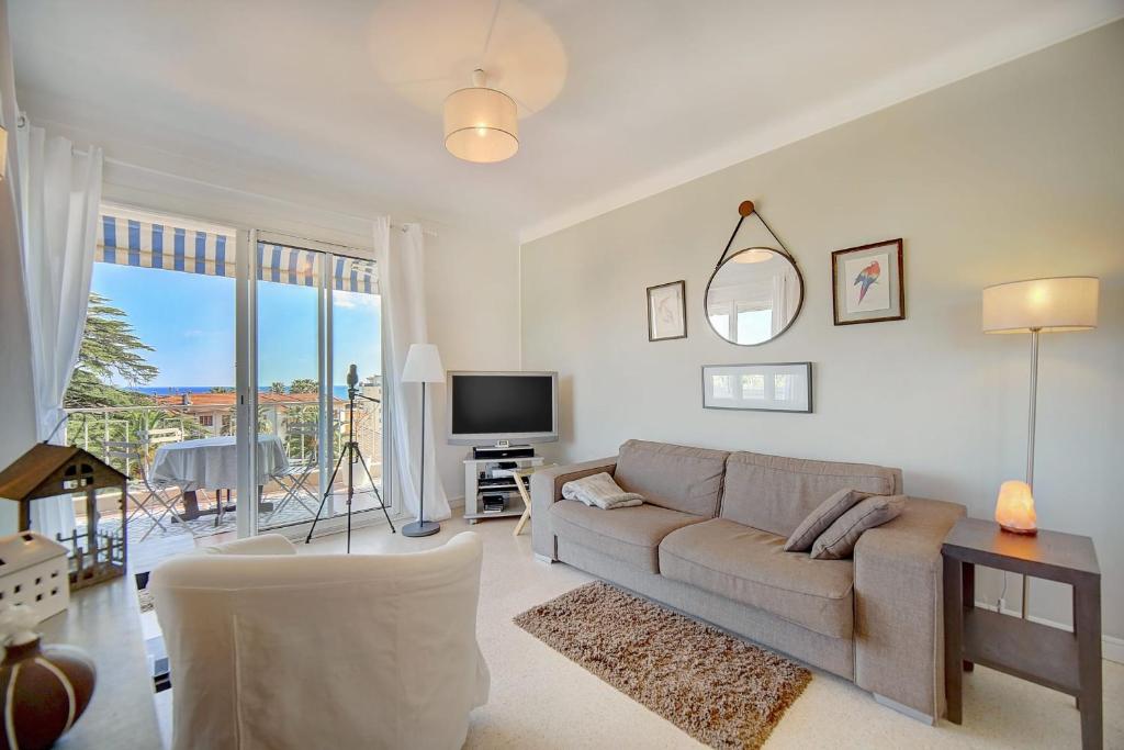 un salon avec un canapé et une télévision dans l'établissement IMMOGROOM - Close beaches- Beautiful terrace - Seaview - CONGRESSBEACHES, à Cannes