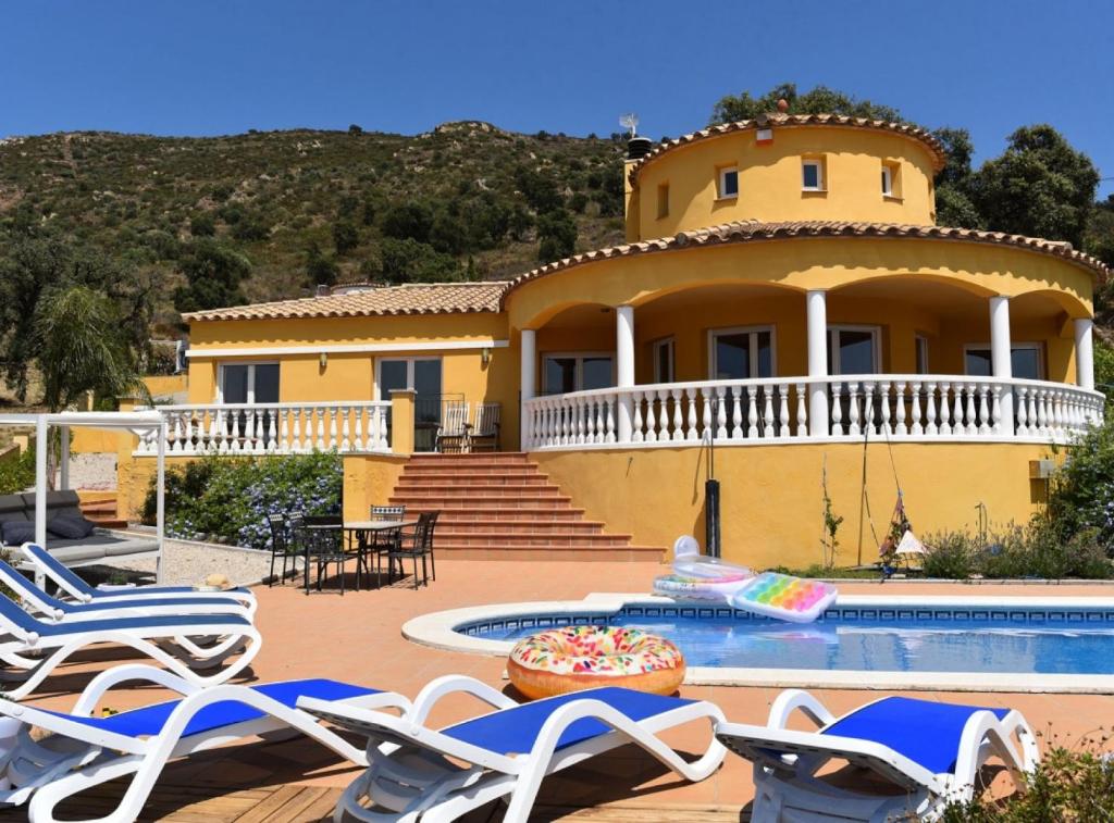 une maison jaune avec des chaises et une piscine dans l'établissement Casa Albera - with pool and fantastic views, à Palau-Saverdera