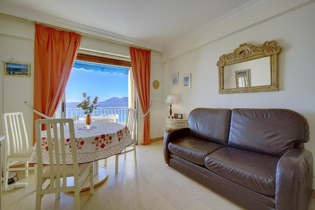 uma sala de estar com um sofá e uma mesa em IMMOGROOM- Sea view - Center- AC- Front of the beaches em Cannes
