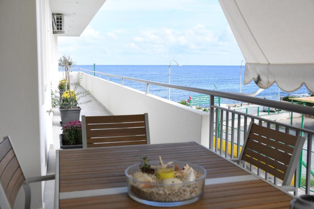 a balcony with a table with a view of the ocean at Ammos Suite in Hersonissos