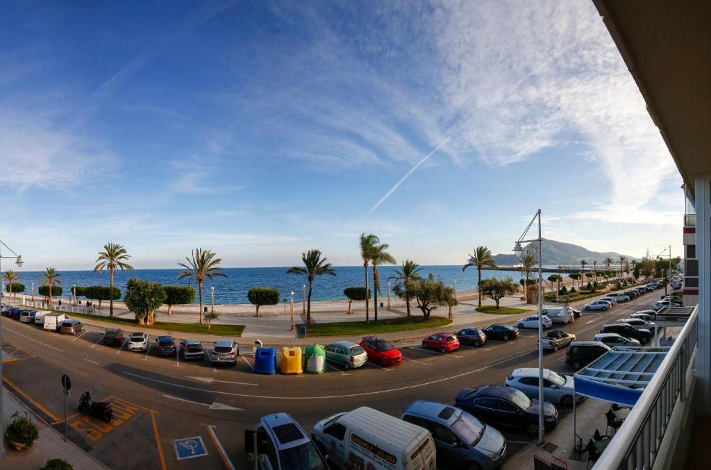 a view of a parking lot with cars and the ocean at Luxury Ocean Beach Apartment in Altea