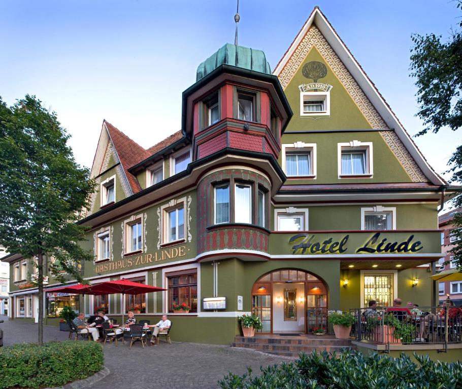 a hotel building with people sitting outside of it at Hotel Linde in Donaueschingen