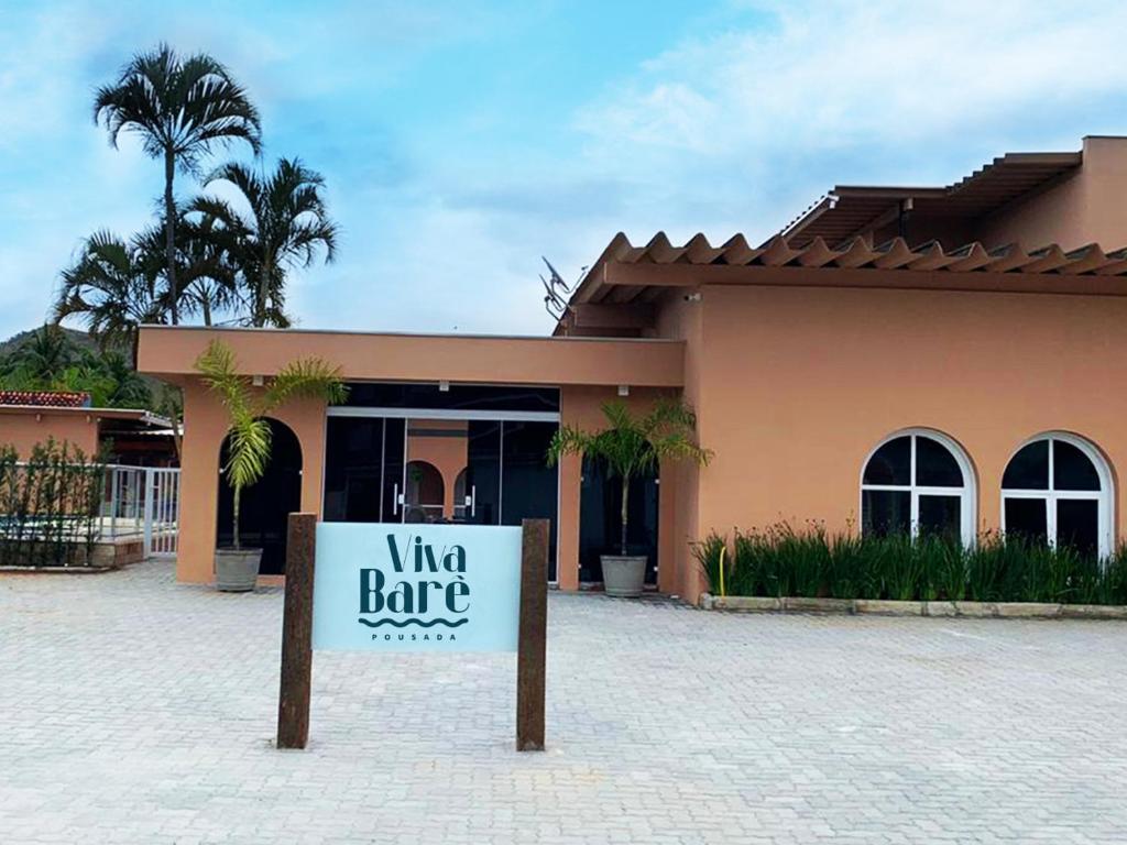 um sinal em frente a um edifício com uma garagem de vinhos em Viva Barê Pousada em São Sebastião