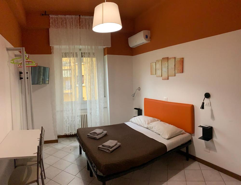 um quarto com uma cama com uma cabeceira laranja em marconi 22 rooms em Bolonha